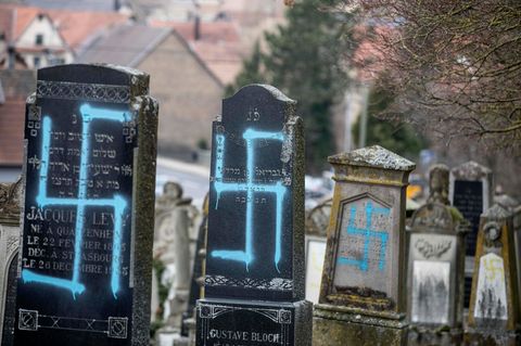 Mit Hakenkreuz beschmierte Grabsteine auf einem Friedhof
