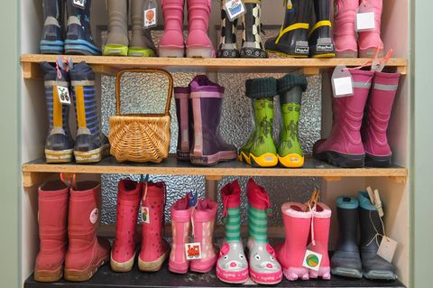 Gummistiefel von Kindern in einem Regal eines Kindergartens