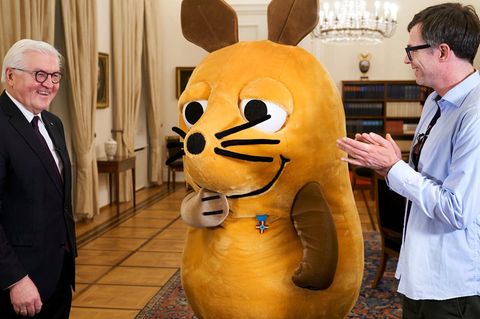 Bundespräsident Frank-Walter Steinmeier, die Maus samt Mausverdienstkreuz und Moderator Ralph Caspers