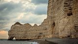 Der Kreidefelsen der Falaises d'Étretat; am linken Bildrand die Porte d'Amont, das kleinste der drei berühmten Felsentore von Étretat.