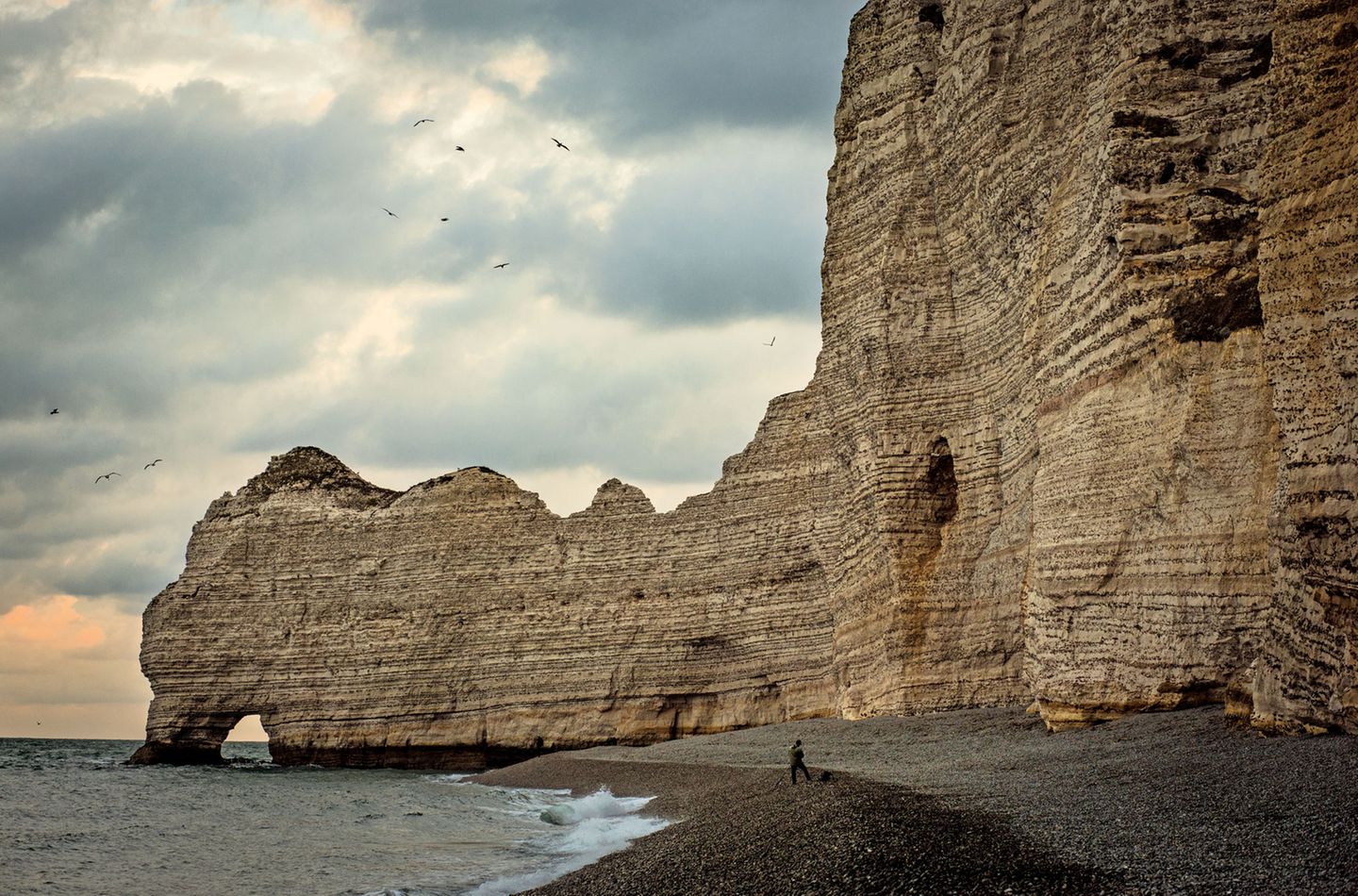 Der Kreidefelsen der Falaises d'Étretat; am linken Bildrand die Porte d'Amont, das kleinste der drei berühmten Felsentore von Étretat.