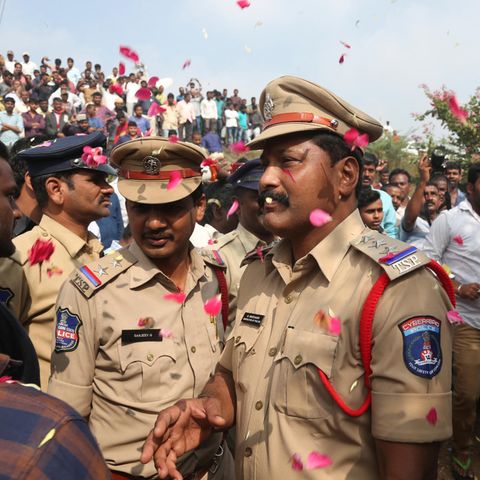 Menschen werfen Blütenblätter auf indische Polizisten