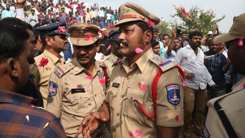 Menschen werfen Blütenblätter auf indische Polizisten