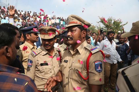 Menschen werfen Blütenblätter auf indische Polizisten