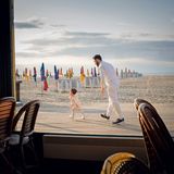 Ein Vater beim Spiel mit seiner Tochter vor einer Strandbar in Deauville. 