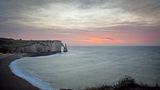 Die Küste von Étretat nach Sonnenuntergang, mit der Porte d’Aval im Hintergrund. 