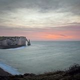 Die Küste von Étretat nach Sonnenuntergang, mit der Porte d’Aval im Hintergrund. 