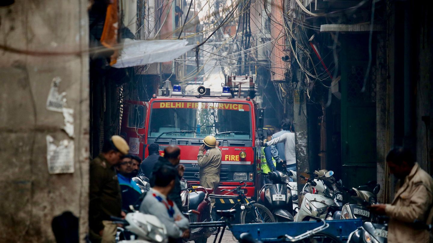 Ein Feuerwehrwagen steht in einer engen Gasse in einem abgesperrten Bereich vor einem Gebäude, in dem es gebrannt hat.