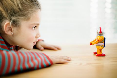 Ein Kind schaut auf einen Spielzeug-Roboter