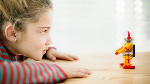 Ein Kind schaut auf einen Spielzeug-Roboter