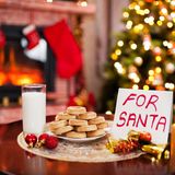 Milch und Kekse vor einem Weihnachtsbaum