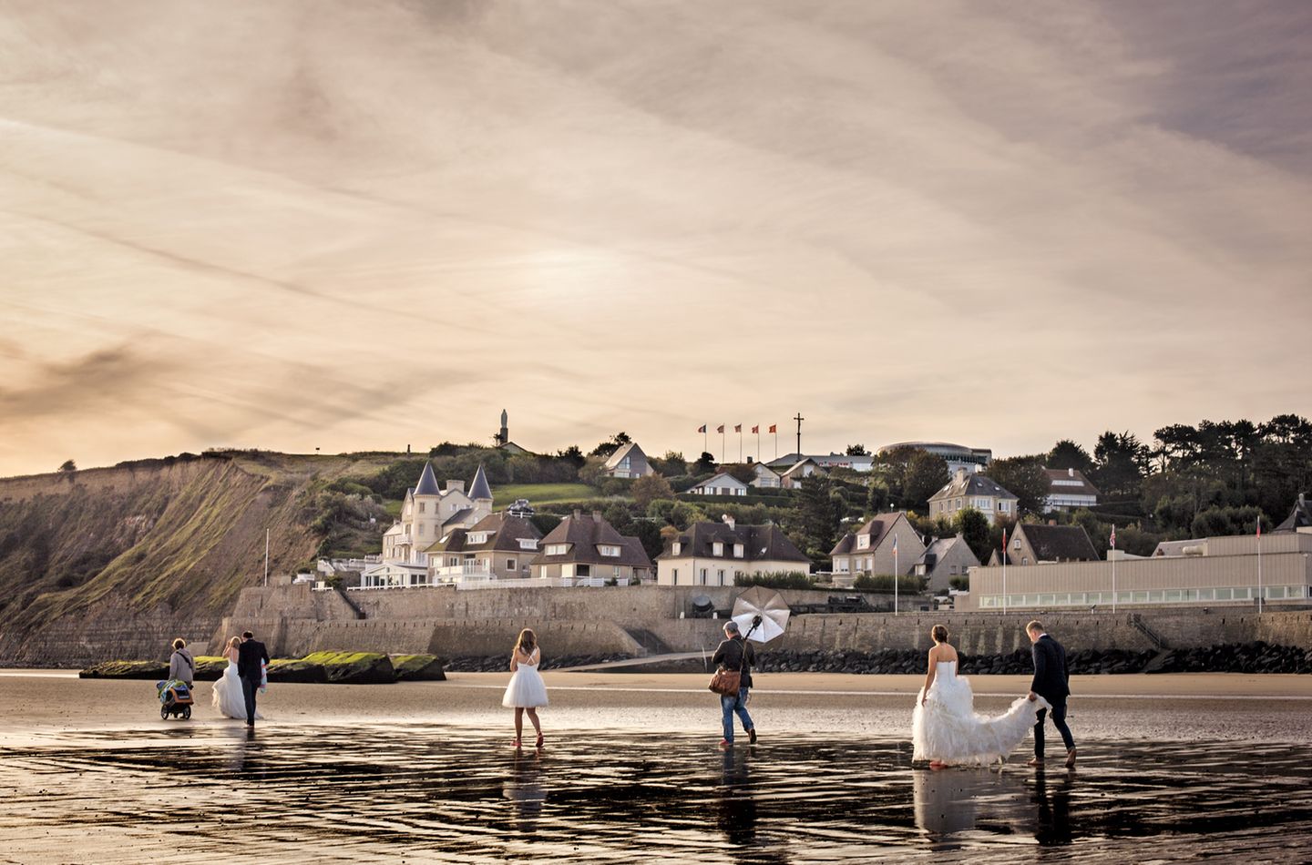 Ein Brautmoden-Fotoshooting morgens am Strand von Arromanches. Im Hintergrund sind Reste des Atlantikwalls zu sehen, mit denen die deutsche Wehrmacht eine Invasion der Alliierten zu verhindern suchte. 
