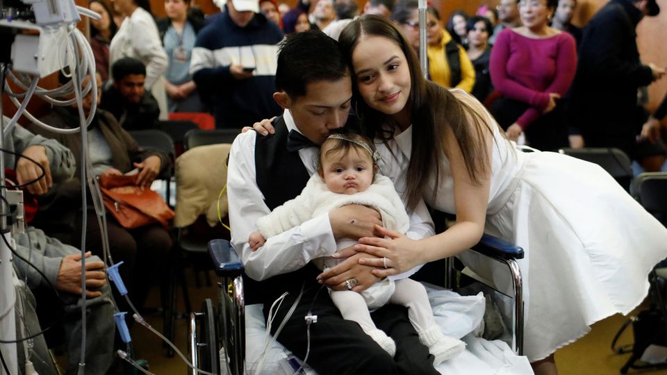 Hochzeit Bräutigam Javier Rodriguez hält seine vier Monate alte Tochter Leia
