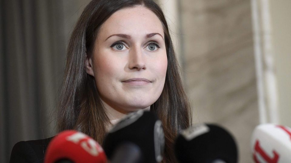 Sanna Marin vor mehreren Mikrofonen Sanna Marin vor mehreren Mikrofonen