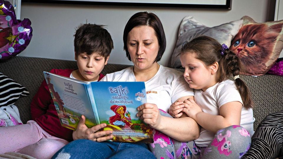 Daria (l.) und Oliwia (r.) lieben es, wenn ihre Mutter, Katarzyna Märchen vorliest