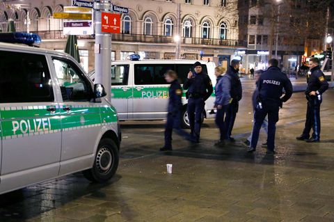 Polizisten stehen am Augsburger Königsplatz am Tatort