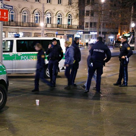 Polizisten stehen am Augsburger Königsplatz am Tatort