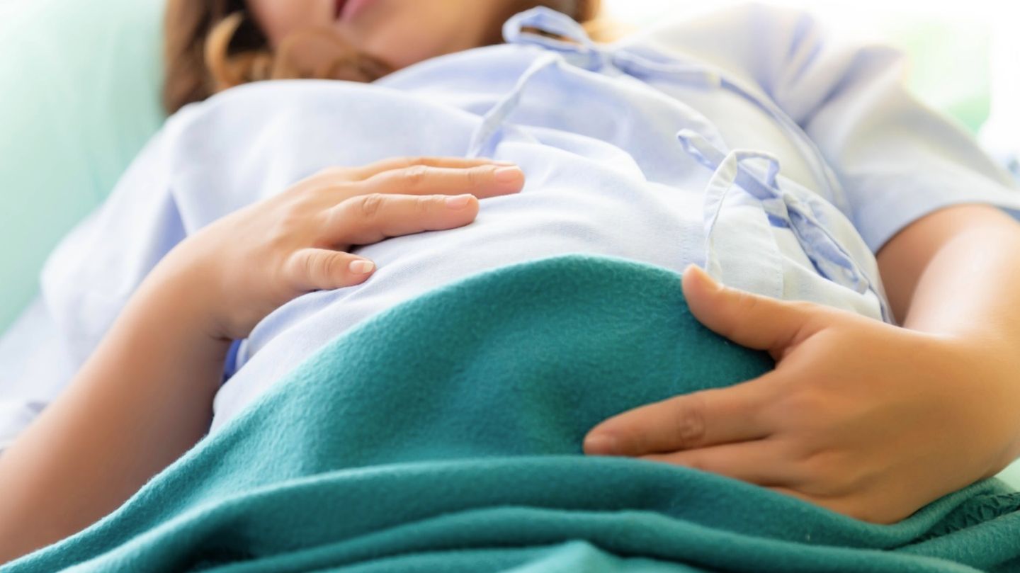 Eine schwangere Frau hält sich den Bauch