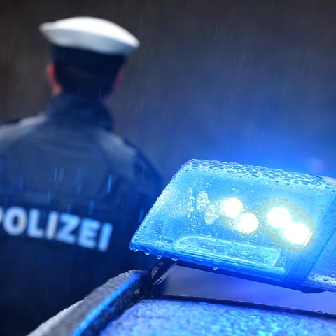 Ein Polizist und ein Polizeifahrzeug