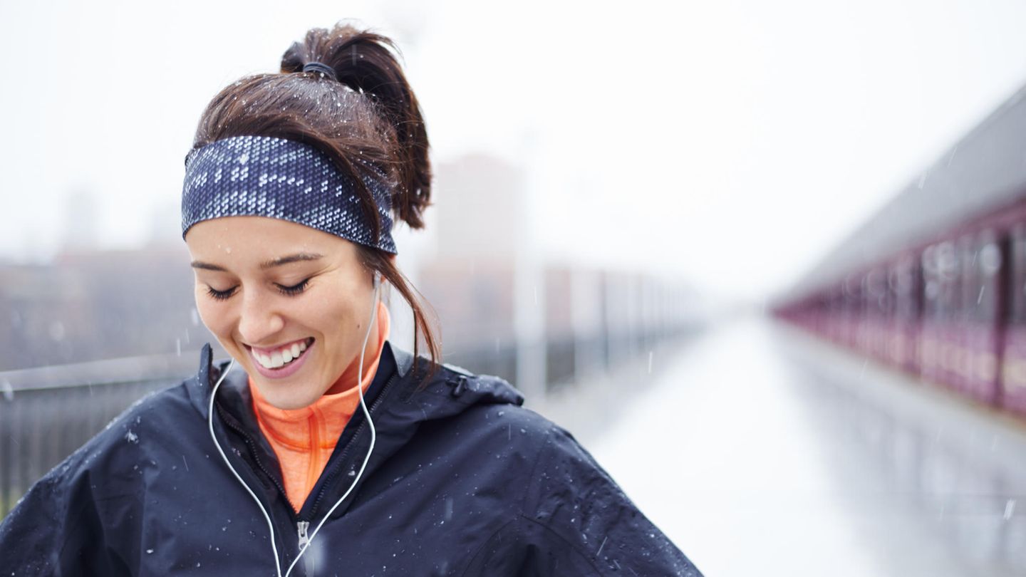 Eine junge Frau joggt im Schnee