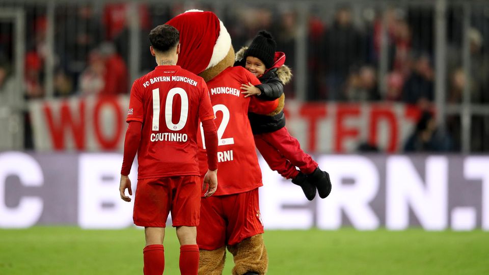Philippe Coutinho freut sich nach dem Sieg gegen Bremen zusammen mit seinem Sohn und dem Bayern-Maskottchen