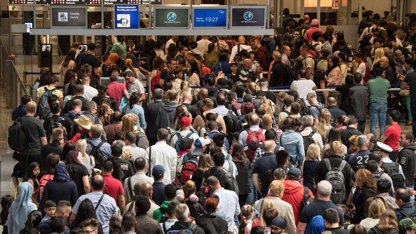 Im Stau vor der Security: Reisende stehen in einer langen Schlange vor der Sicherheitskontrolle im Terminal 2 des Flughafens