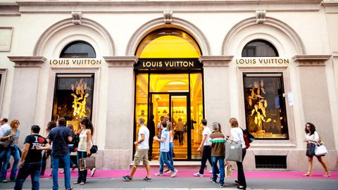 Menschen in einer luxuriösen Einkaufsstraße vor einer "Louis Vuitton"Filliale