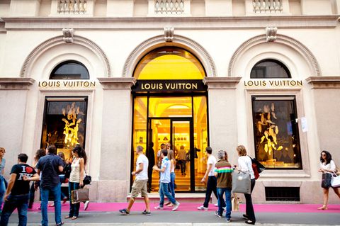 Menschen in einer luxuriösen Einkaufsstraße vor einer "Louis Vuitton"Filliale