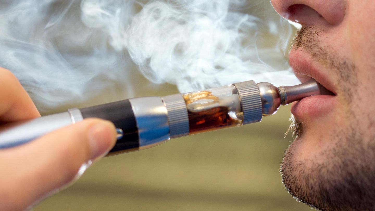 E-Zigarette: Ein junger mann benutzt eine E-Zigarette