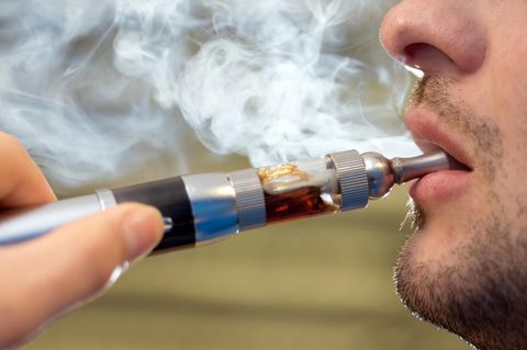 E-Zigarette: Ein junger mann benutzt eine E-Zigarette
