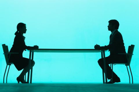 Frau und Mann setzen sich am Tisch gegenüber