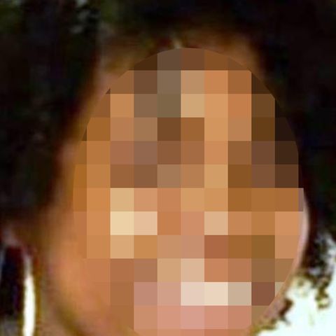 Eine dunkelhäutige Jugendliche lächelt in die Kamera