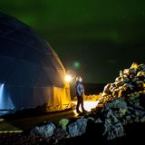 Person steht vor der Glaskuppel