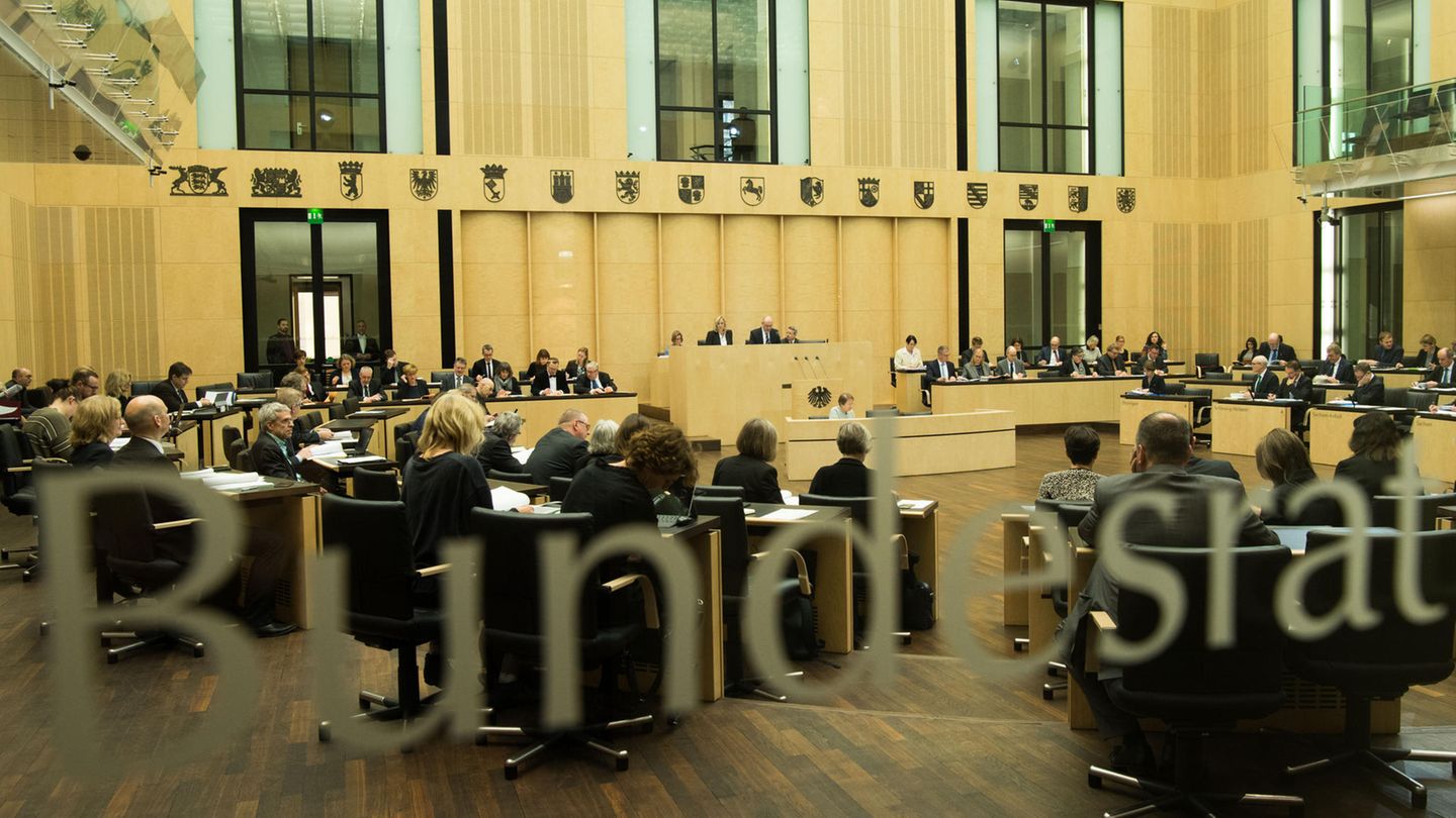 Durch eine Glasscheibe mit "Bundesrat"-Schriftzug ist ein voller Sitzungssaal mit Länderwappen zu sehen