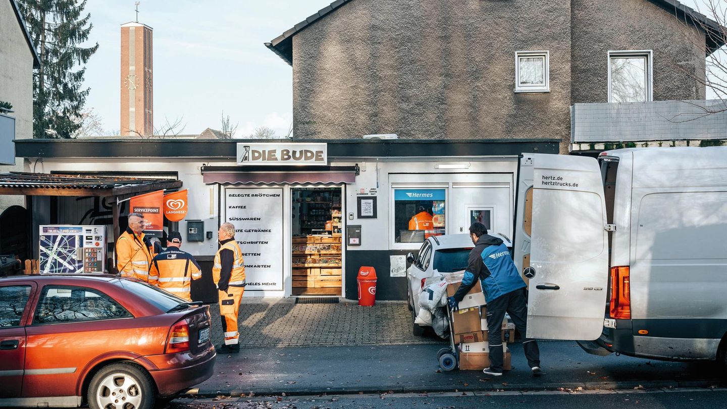 Hermes-Bote Daimi Sario beim Abholen von Paketen im Kiosk "Die Bude" in Marl. Ein Paketbote vor der "Bude"