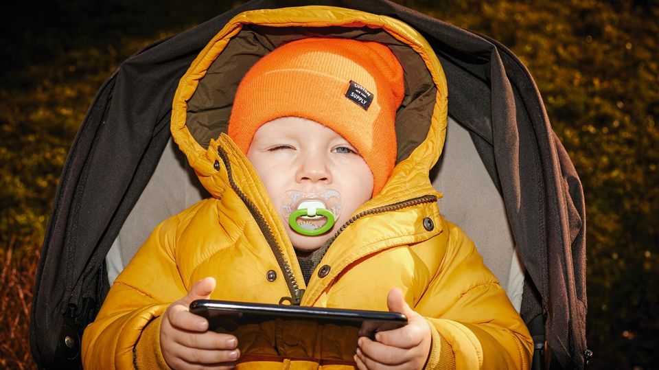 Beispiel-Foto für die Kampagne „OutOfSocial“ Ein kleines Kind mit Schnuller und Tablet