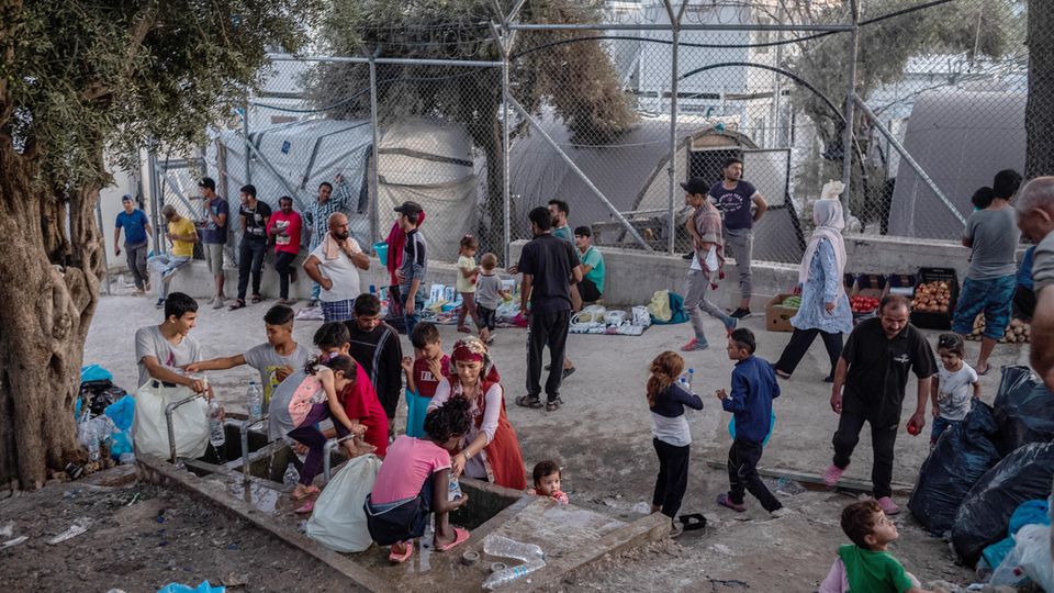 Migranten stehen um eine Wasserstelle und befüllen Flaschen im Flüchtlingslager Moria auf der griechischen Insel Lesbos