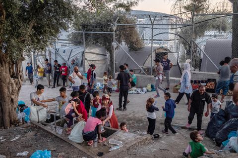 Migranten stehen um eine Wasserstelle und befüllen Flaschen im Flüchtlingslager Moria auf der griechischen Insel Lesbos