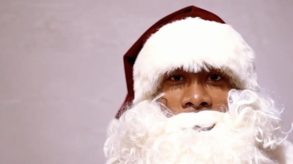 Als Weihnachtsmann mit dickem, weißem Vollbart und roter Weihnachtsmütze schaut David Alaba in die Kamera