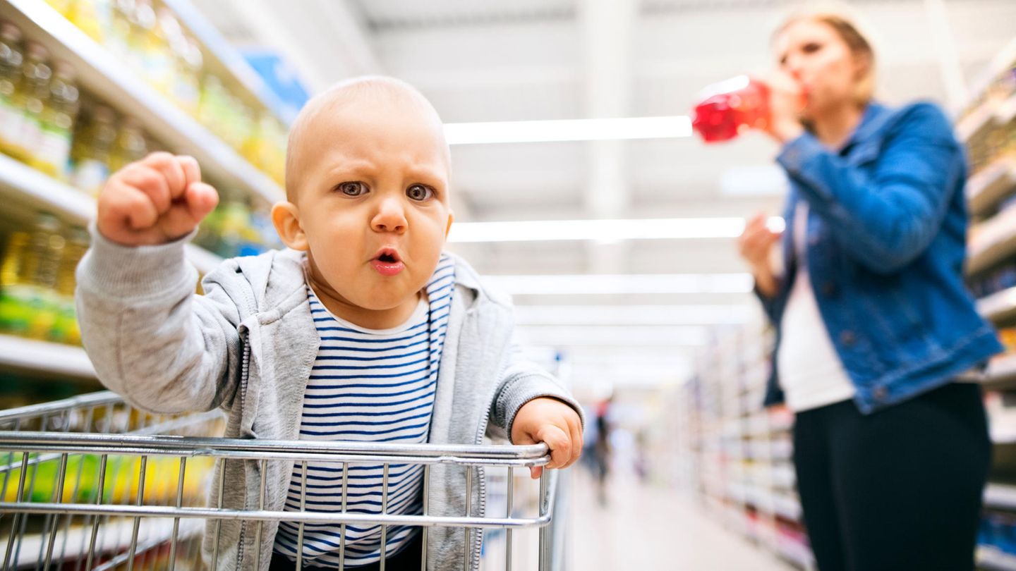 Ein Baby im Einkaufswagen ballt eine Faust