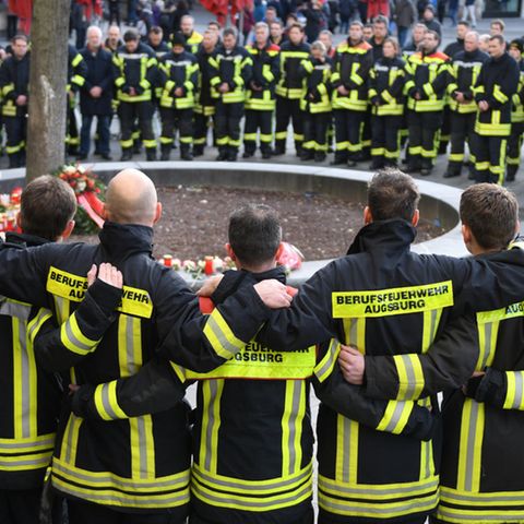 Bayern, Augsburg: Am Königsplatz trauern Feuerwehrmänner