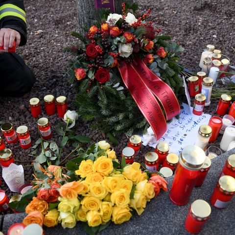 Ein Feuerwehrmann zündet am Königsplatz in Augsburg für seinen toten Kollegen eine Kerze an