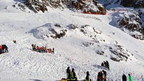 Rettungskräfte arbeiten bei einer Suchaktion nach einer Lawine auf einer Skipiste.