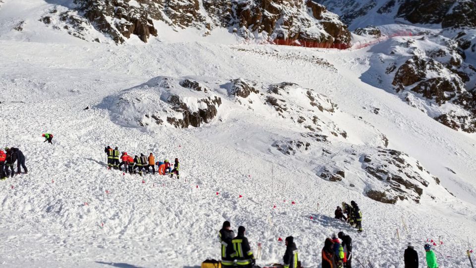 Rettungskräfte arbeiten bei einer Suchaktion nach einer Lawine auf einer Skipiste.