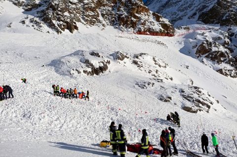 Rettungskräfte arbeiten bei einer Suchaktion nach einer Lawine auf einer Skipiste.