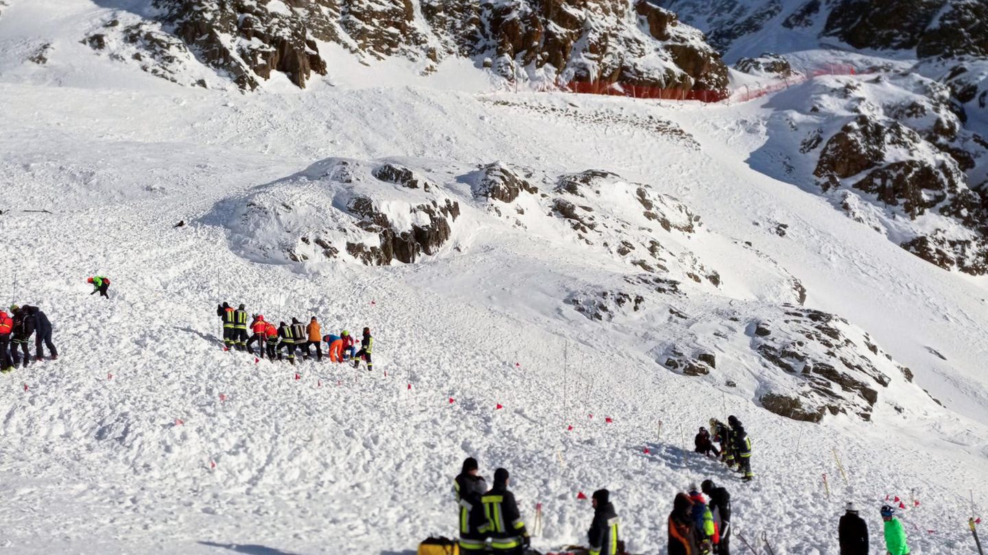 Rettungskräfte arbeiten bei einer Suchaktion nach einer Lawine auf einer Skipiste.