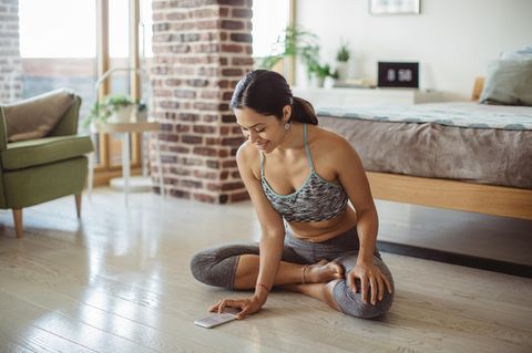 Frau macht Yoga im Schlafzimmer