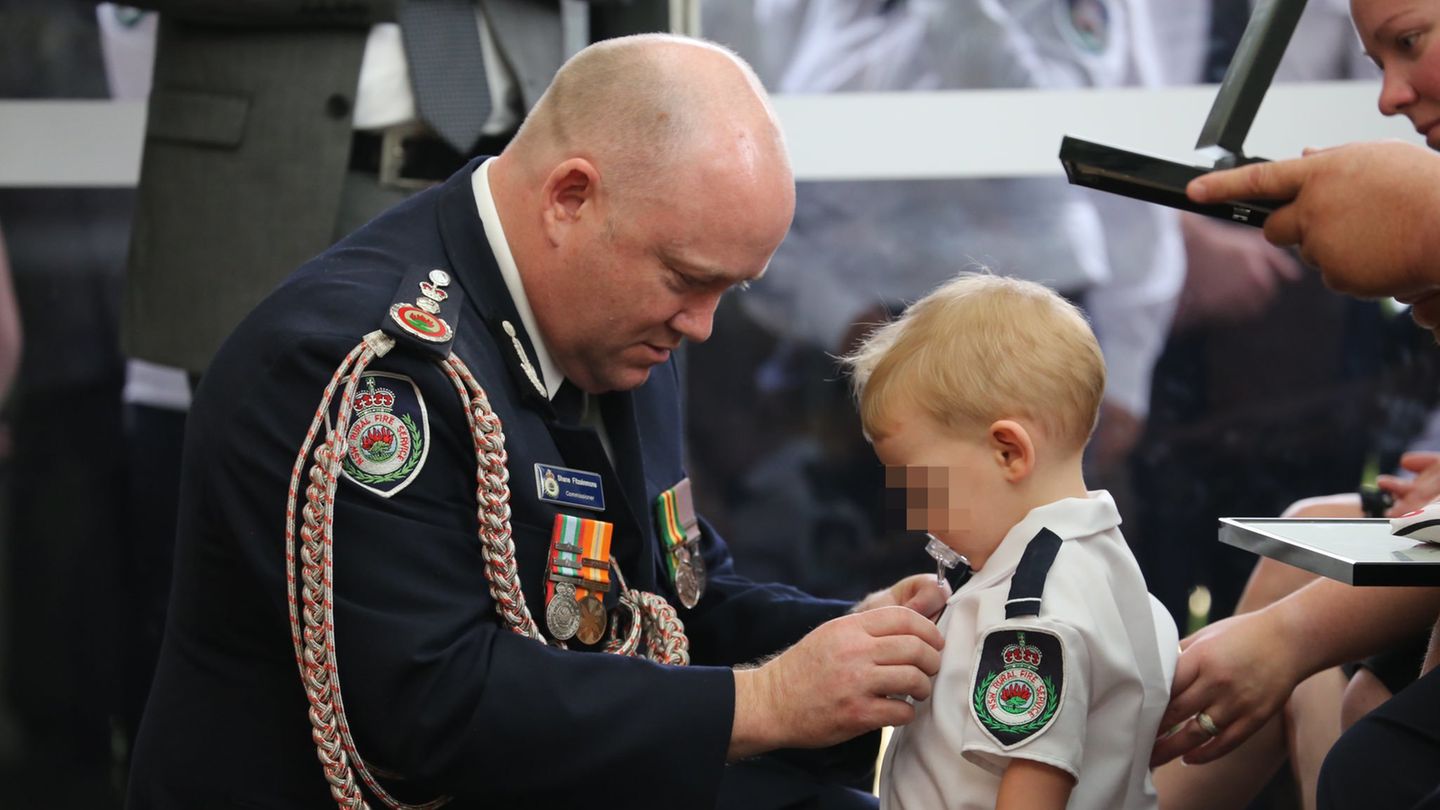 Kommissar Shane Fitzsimmons (l.) überreicht dem Sohn des Feuerwehrmannes Geoffrey Keaton eine posthume Auszeichnung