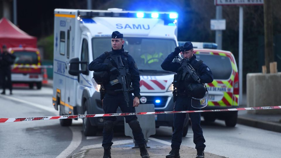 Bei einem Messerangriff nahe Paris ist ein Mensch von einem Angreifer getötet worden Polizisten stehen vor einem Krankenwagen