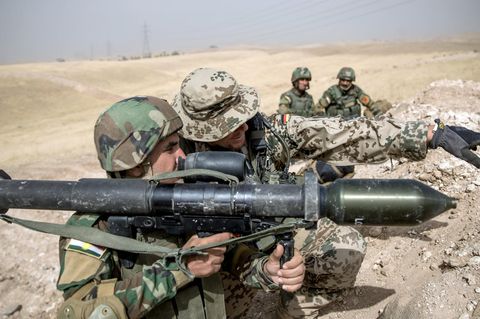 Ein Soldat der Bundeswehr weist einen Angehörigen der Peschmerga  ein